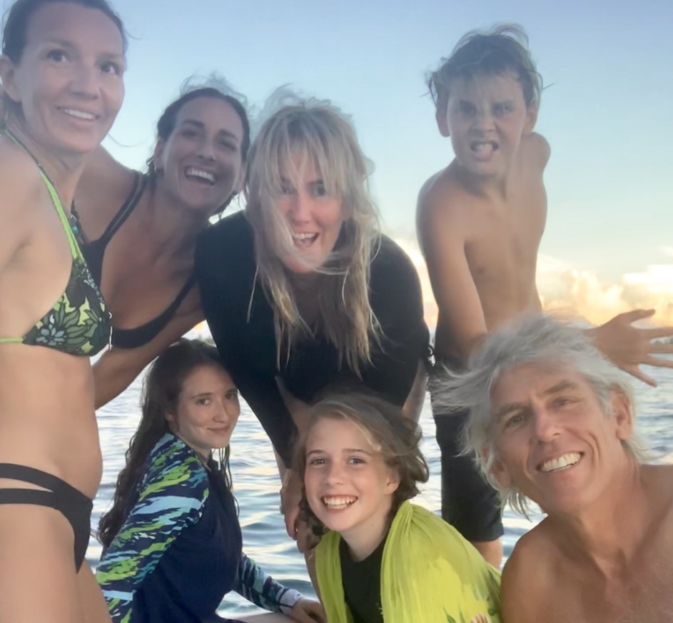 Joe smiling with a joyful small group by the ocean